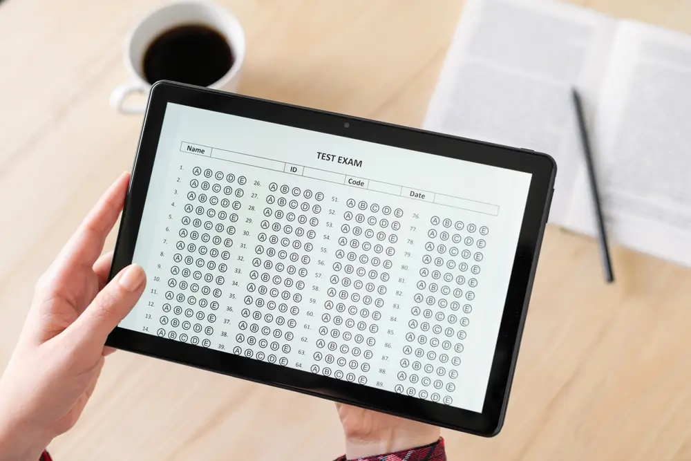 Candidat passant un test de logique sur tablette, illustrant un test d'aptitude sur ordinateur à choix multiples.