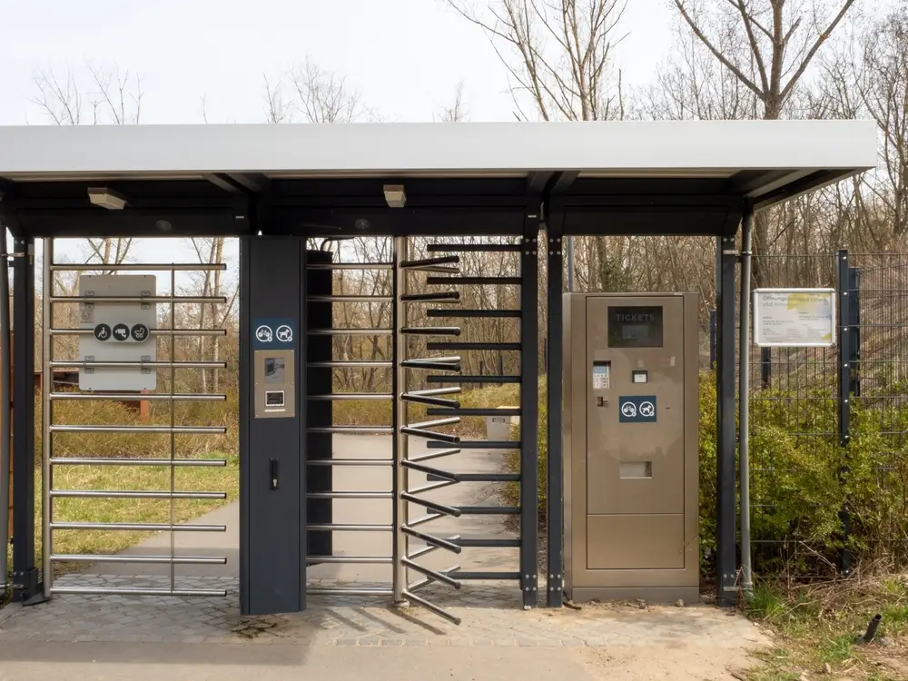 Tourniquets de sécurité et borne d'accès contrôlant l'entrée d'un bâtiment de centre de formation.