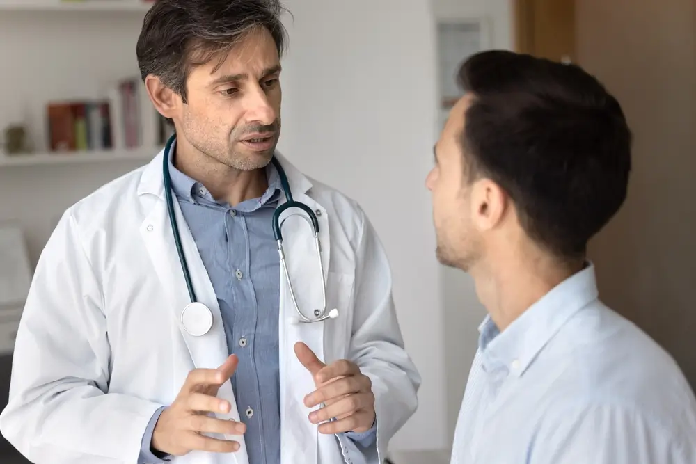 Médecin du travail expliquant l'examen d'aptitude médicale à un futur assistant de surveillance pénitentiaire.