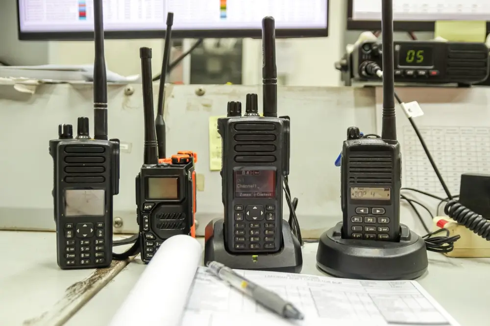 Radios talkies-walkies de sécurité sur un poste de travail avec des rapports, illustrant le matériel professionnel.