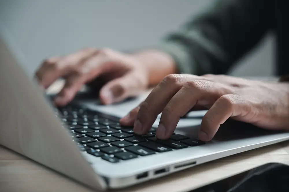 Mains d'un candidat tapant sur un clavier d'ordinateur lors d'un test de sélection informatique du Selor.