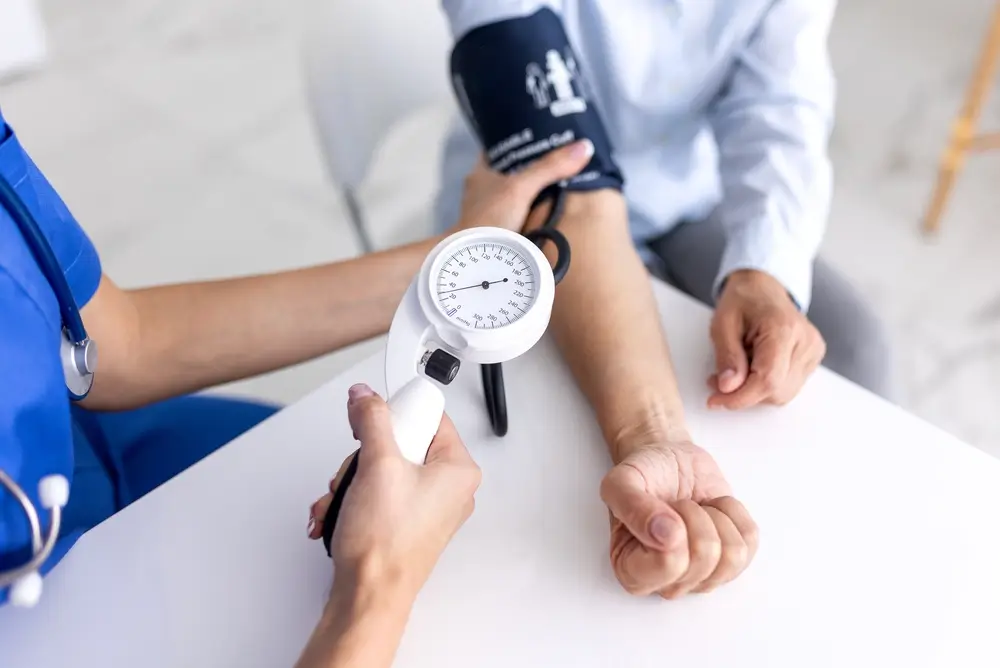Infirmière mesurant la tension d'un candidat lors d'une visite médicale de recrutement.